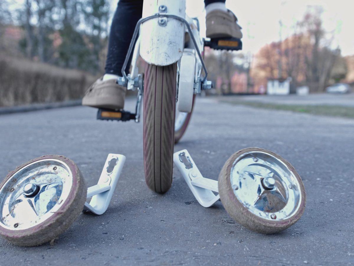 Young Kid Learning To Ride a Bike without Support Stabilizer Wheels Left Behind