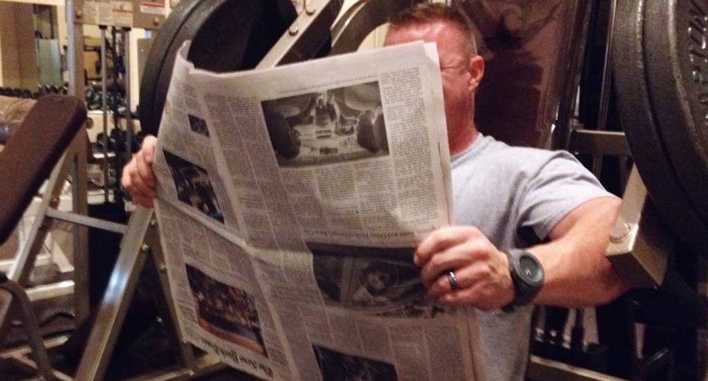 Bodybuilder reading the Paper Upside Down