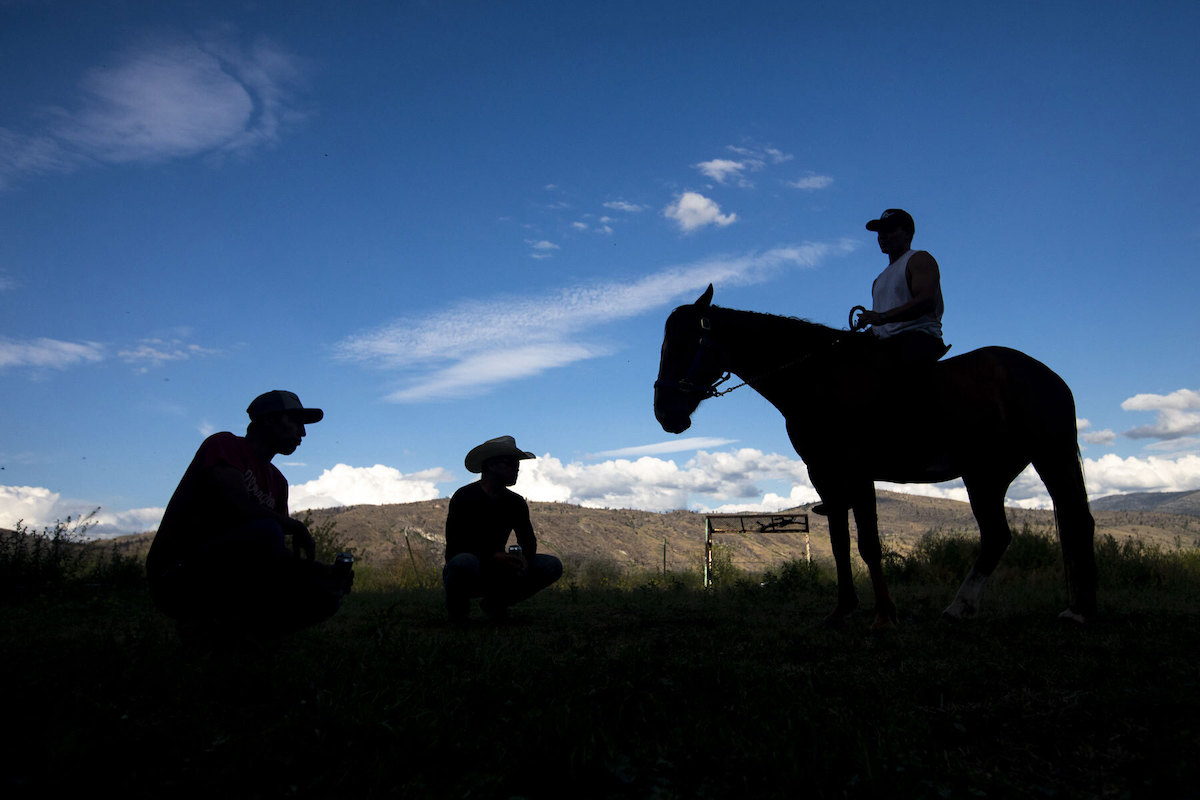 Three men and their house in silhouette